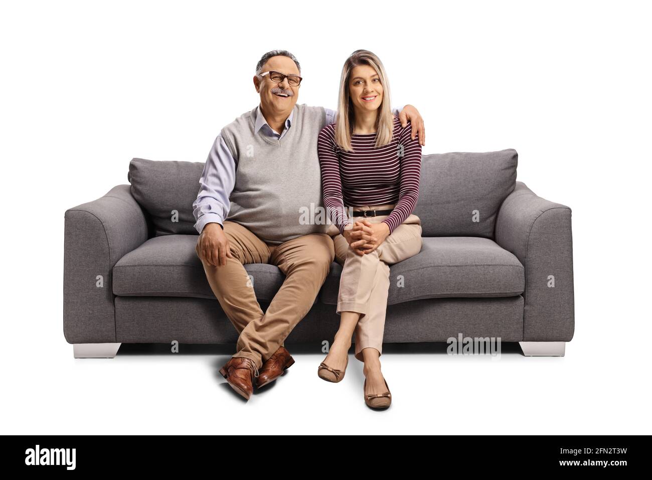 Father and daughter seated on a sofa in embrace isolated on white background Stock Photo