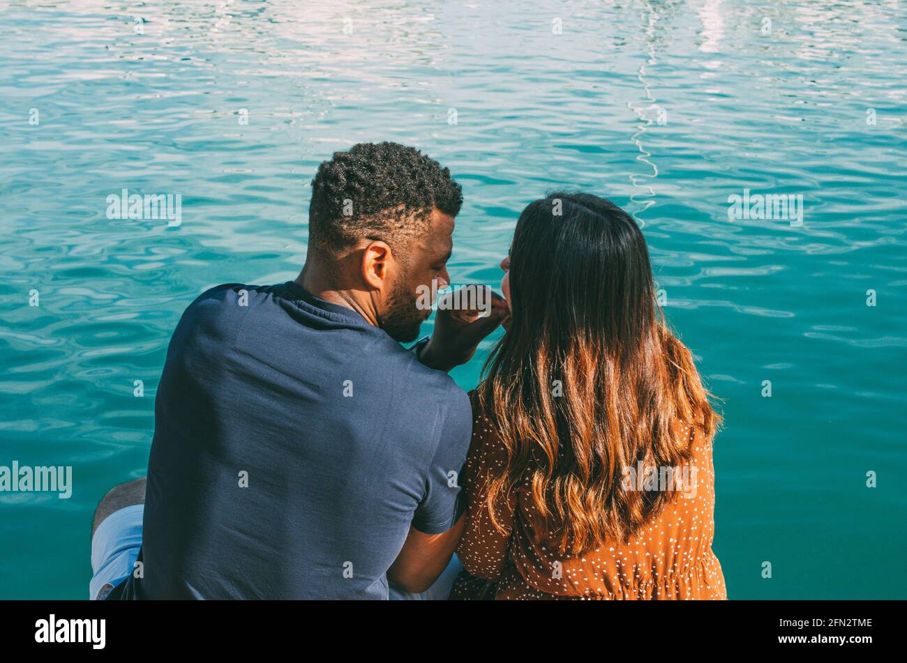 Interracial Couple Cuddling Sitting in Front of the Sea View from the ...