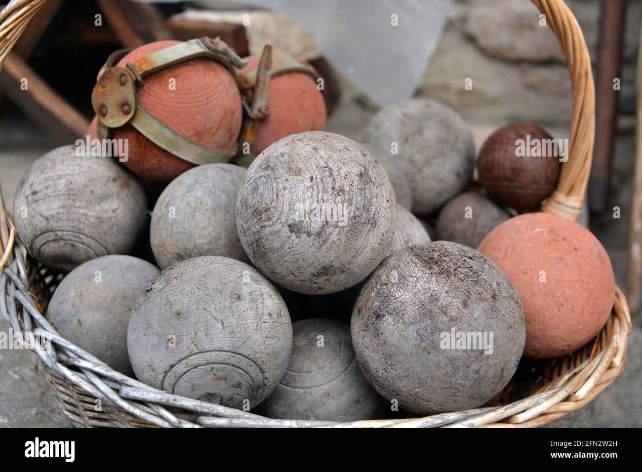 Wicker basket full of antique wooden bowls Stock Photo