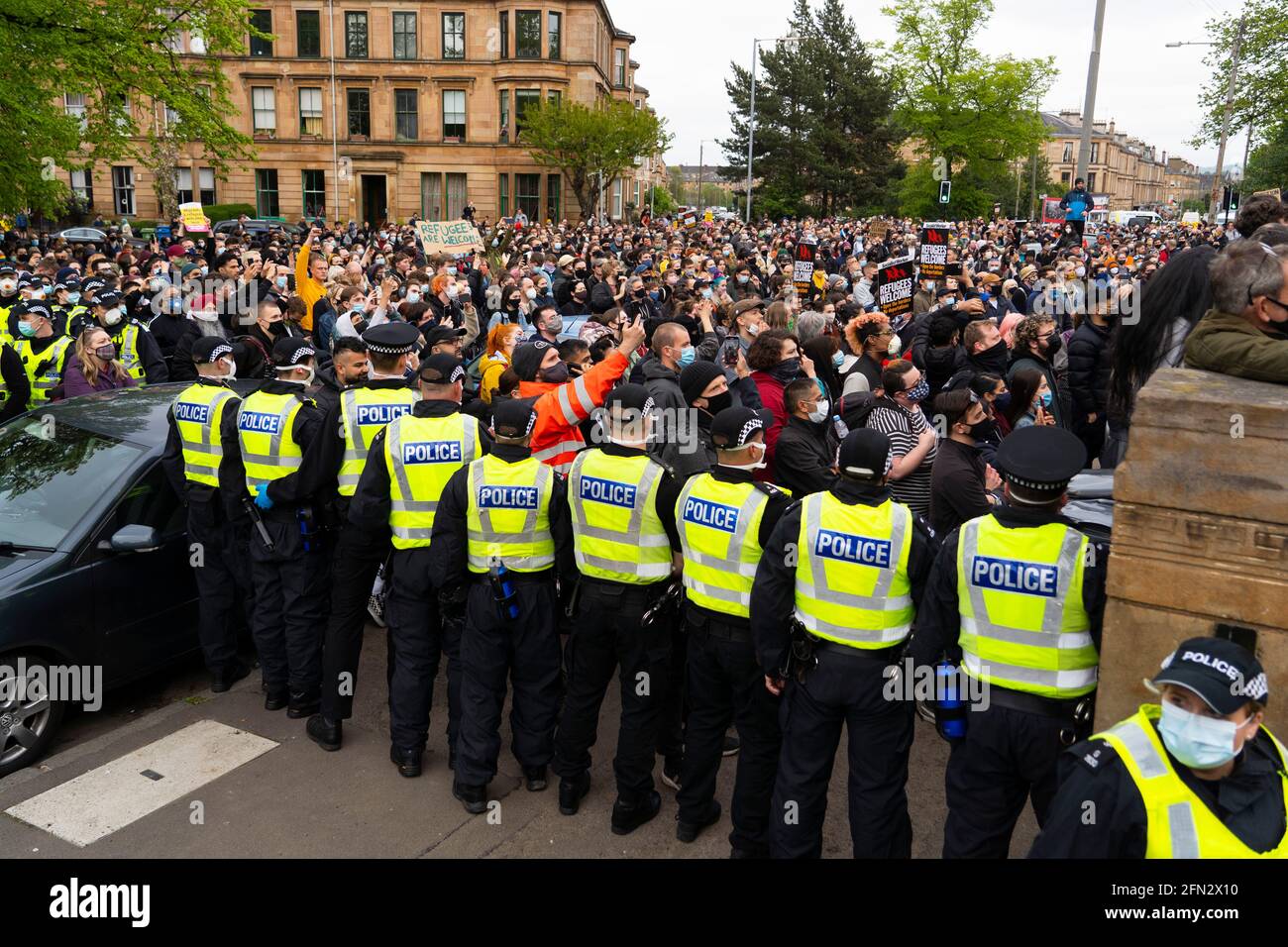 Glasgow, Scotland, UK. 13th May, 2021. At approx 5.30 pm police released two men from a Home Office detention vehicle. Accompanied by lawyer Aamer Anwar the men walked to a nearby mosque surrounded by hundreds of police and supporters who had previously been surrounding the vehicle and sitting on the street. Pic; supporters on street in front of the mosque. Credit: Iain Masterton/Alamy Live News Stock Photo