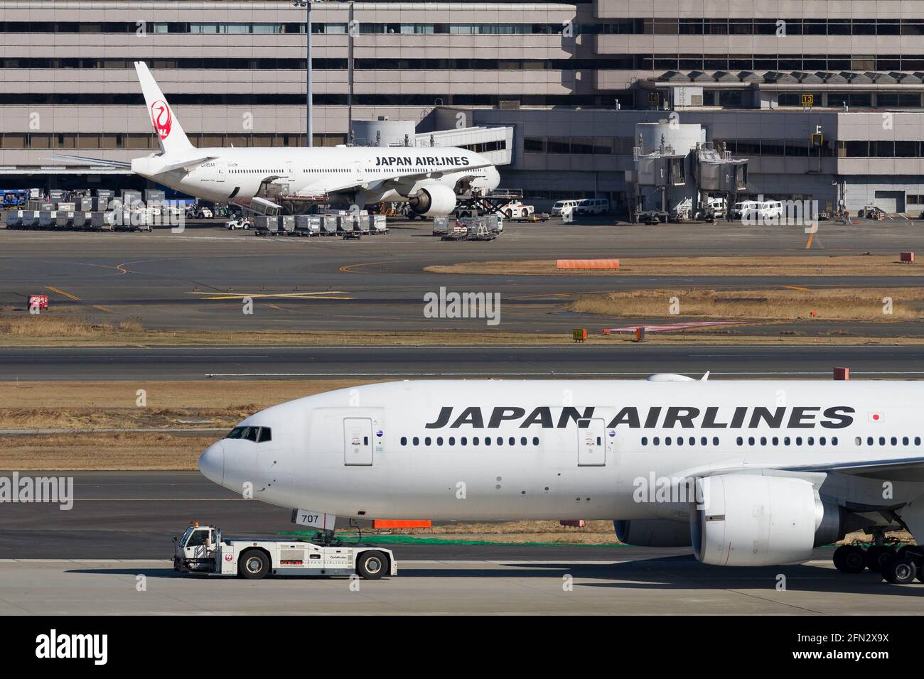 A Japan Airlines (JAL) Boeing 777-246 (ER) being towed at Haneda International Airport. Stock Photo