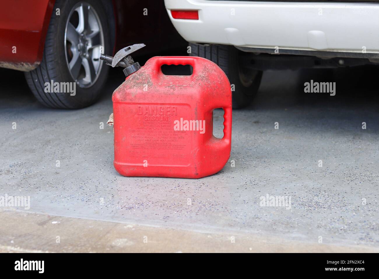 A red plastic gas canister sitting on the ground Stock Photo Alamy