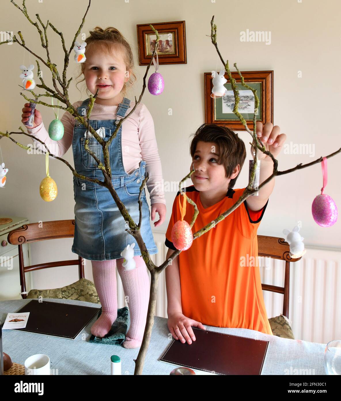 Family children celebrating Easter with egg tree Britain Uk. party fun easter egg hunt Stock Photo