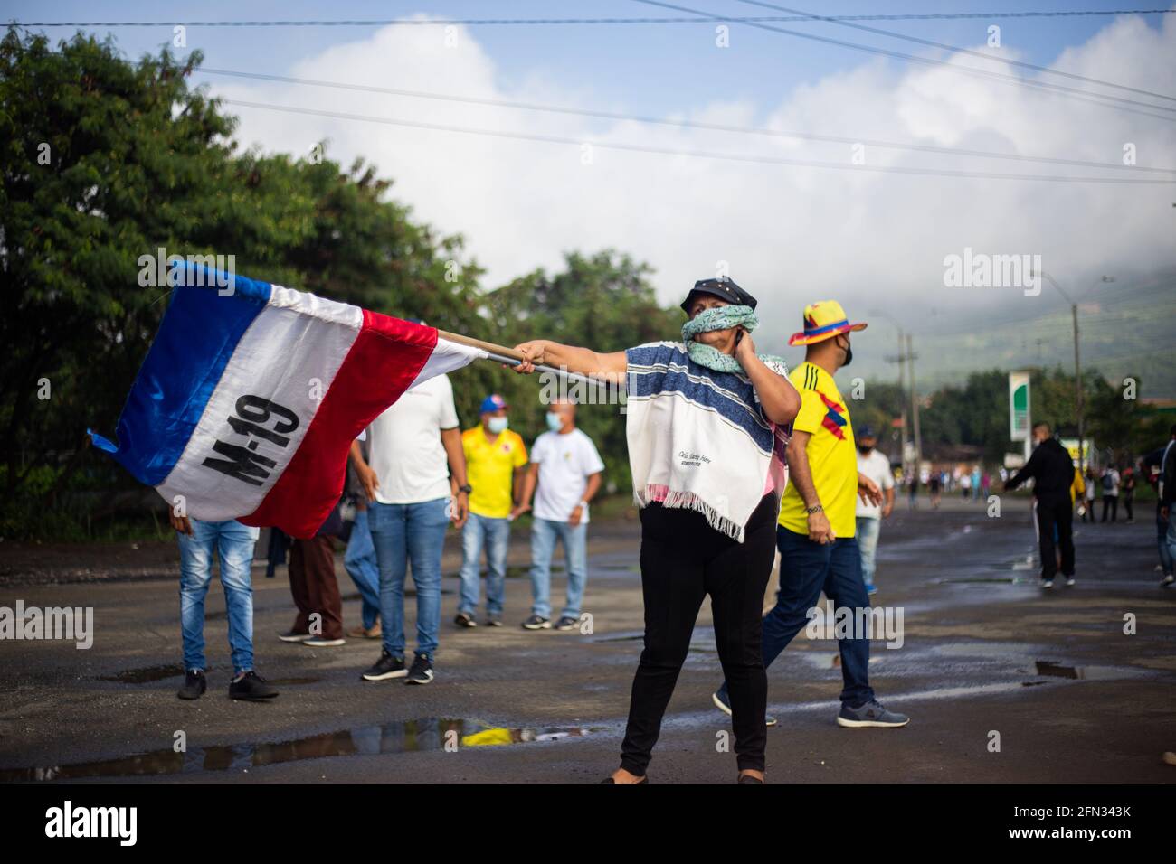 A demonstrator waves the flag of the non-existant guerrilla M-19 as demonstrators gather during the first day of anti-government protests against the tax reform and health reform of president Ivan Duque in Yumbo, Valle del Cauca on April 28, 2021. Later in the day demonstrations rised to riots and several deaths in police brutality cases in the department of Valle del Cauca. Stock Photo