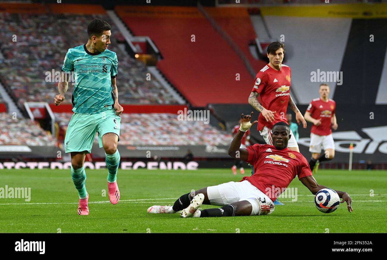Liverpool's Roberto Firmino (left) has a shot blocked by Manchester United's Eric Bailly during the Premier League match at Old Trafford, Manchester. Picture date: Thursday May 13, 2021. Stock Photo
