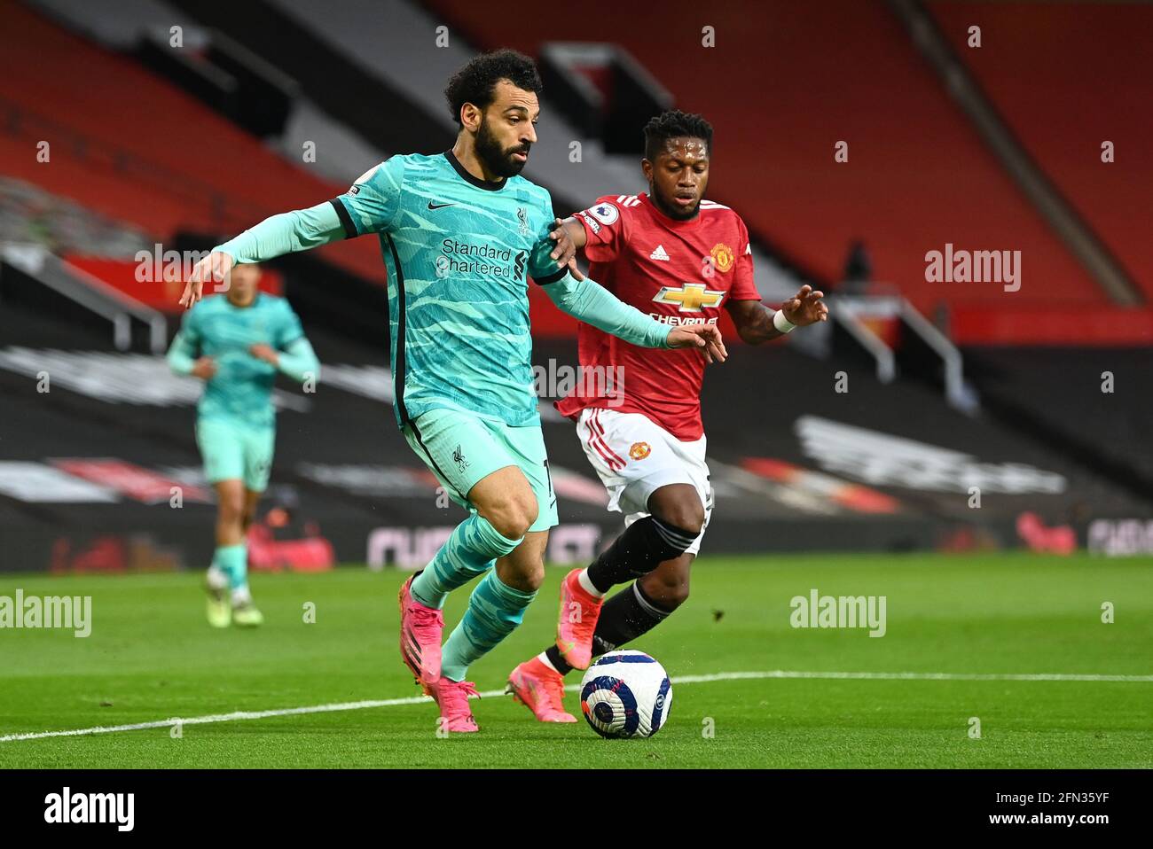 Liverpool's Mohamed Salah (left) and Manchester United's Fred battle for the ball during the Premier League match at Old Trafford, Manchester. Picture date: Thursday May 13, 2021. Stock Photo