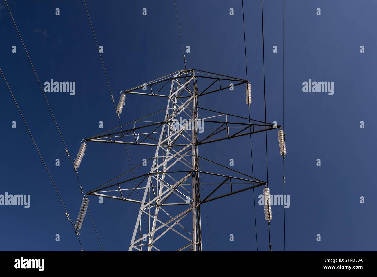 High voltage electricity pylon in sunlight Stock Photo