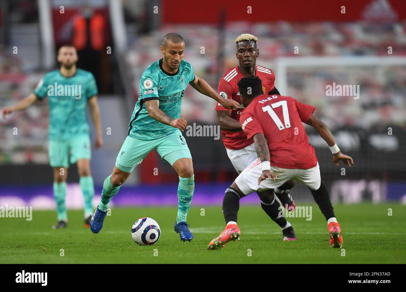 Liverpool's Thiago Alcantara (left) in action with Manchester United's Paul Pogba (centre) and Fred during the Premier League match at Old Trafford, Manchester. Picture date: Thursday May 13, 2021. Stock Photo