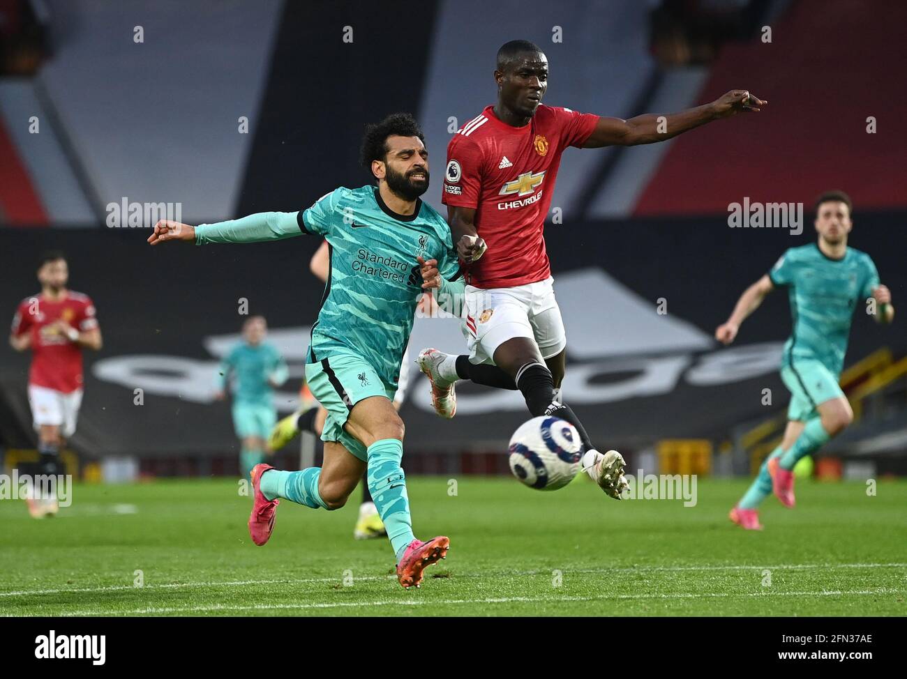 Liverpool's Mohamed Salah (left) and Manchester United's Eric Bailly battle for the ball during the Premier League match at Old Trafford, Manchester. Picture date: Thursday May 13, 2021. Stock Photo
