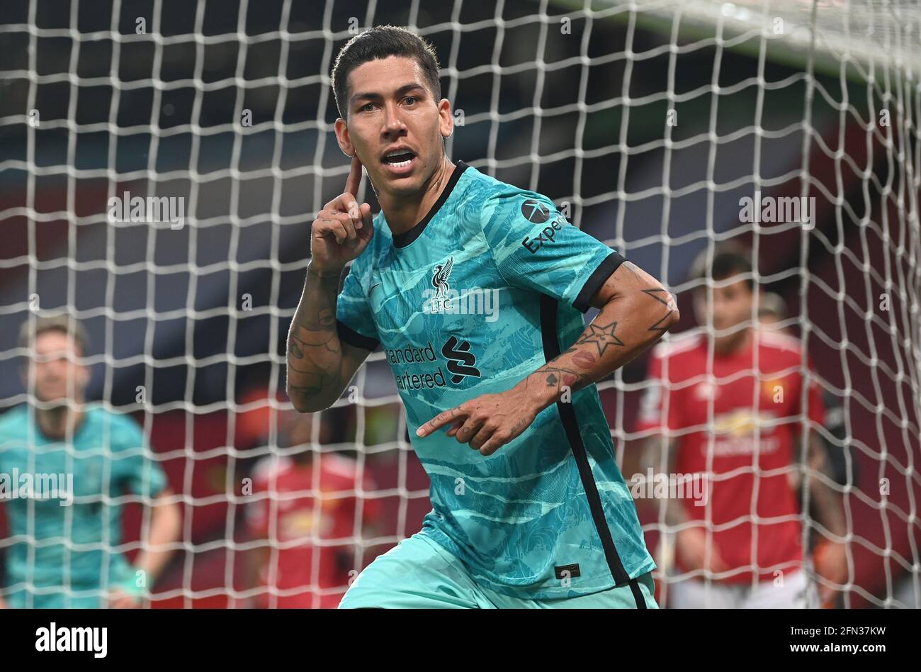 Liverpool's Roberto Firmino celebrates scoring their side's second goal of the game during the Premier League match at Old Trafford, Manchester. Picture date: Thursday May 13, 2021. Stock Photo