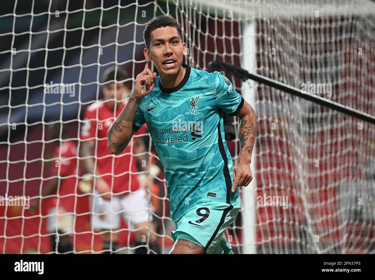 Liverpool's Roberto Firmino celebrates scoring their side's second goal of the game during the Premier League match at Old Trafford, Manchester. Picture date: Thursday May 13, 2021. Stock Photo