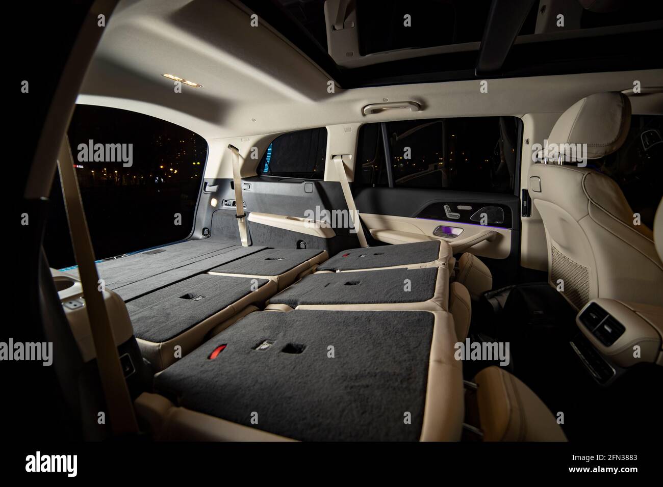 roomy empty interior of premium suv. rear seats folded in flat flor in luxury expencive suv car. side view of flat flor trunk Stock Photo