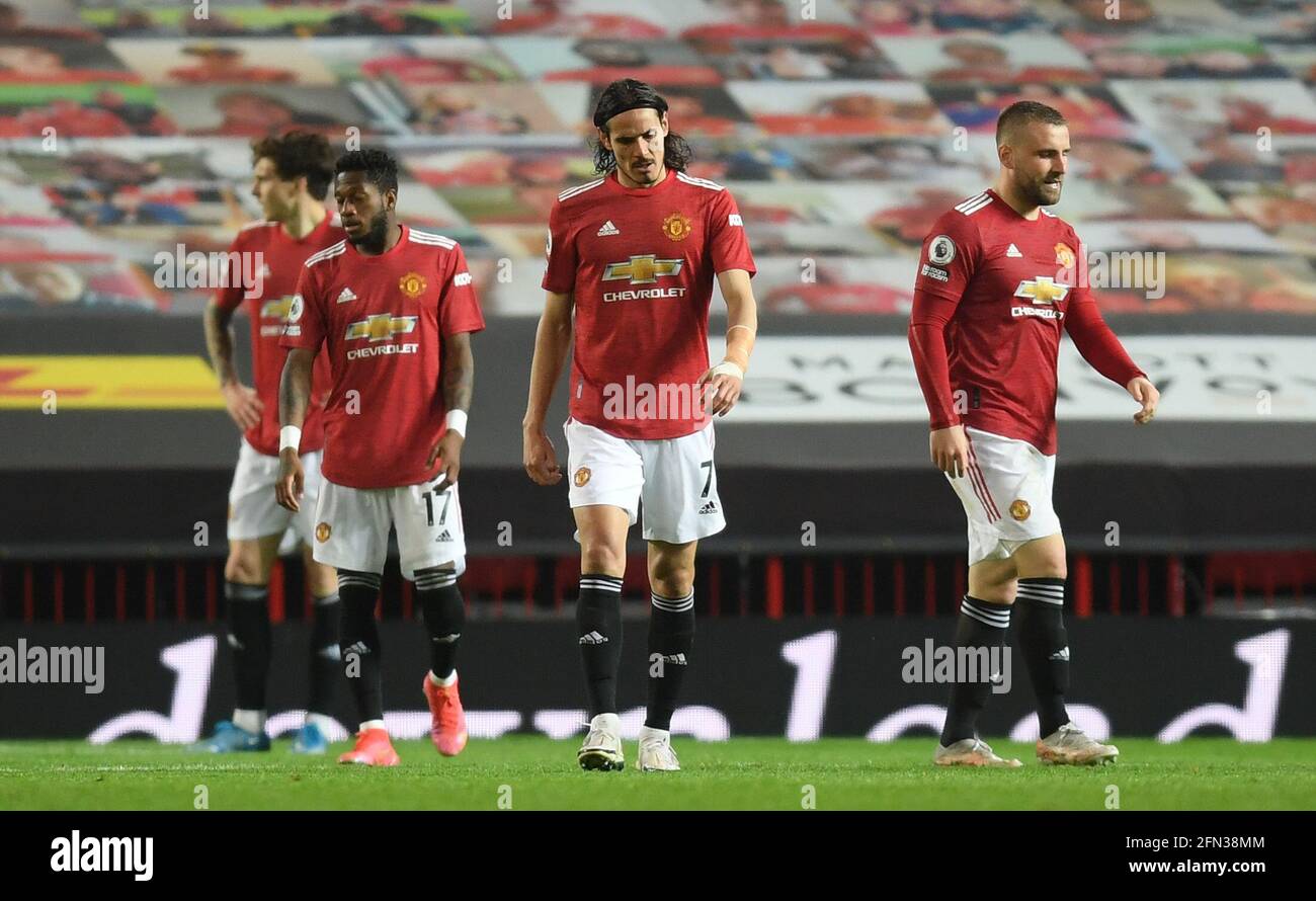 Manchester United's Edinson Cavani (centre) and Luke Shaw (right) appear dejected after they concede a third goal during the Premier League match at Old Trafford, Manchester. Picture date: Thursday May 13, 2021. Stock Photo