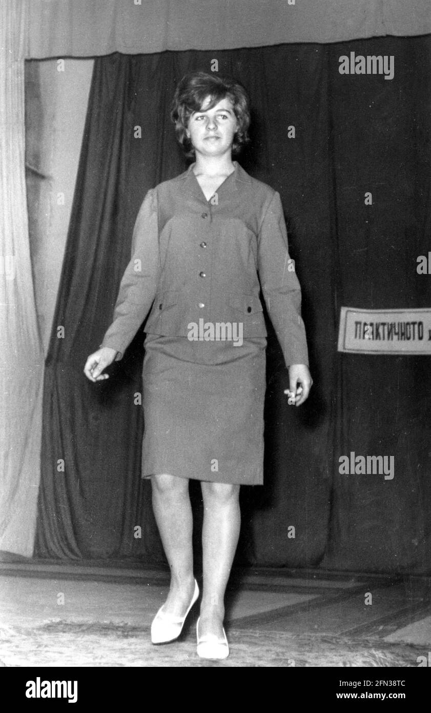 Female model on platform ramp demonstrating new clothing collection at an indoor fashion show in the 1960s, Bulgaria, Eastern Europe Stock Photo