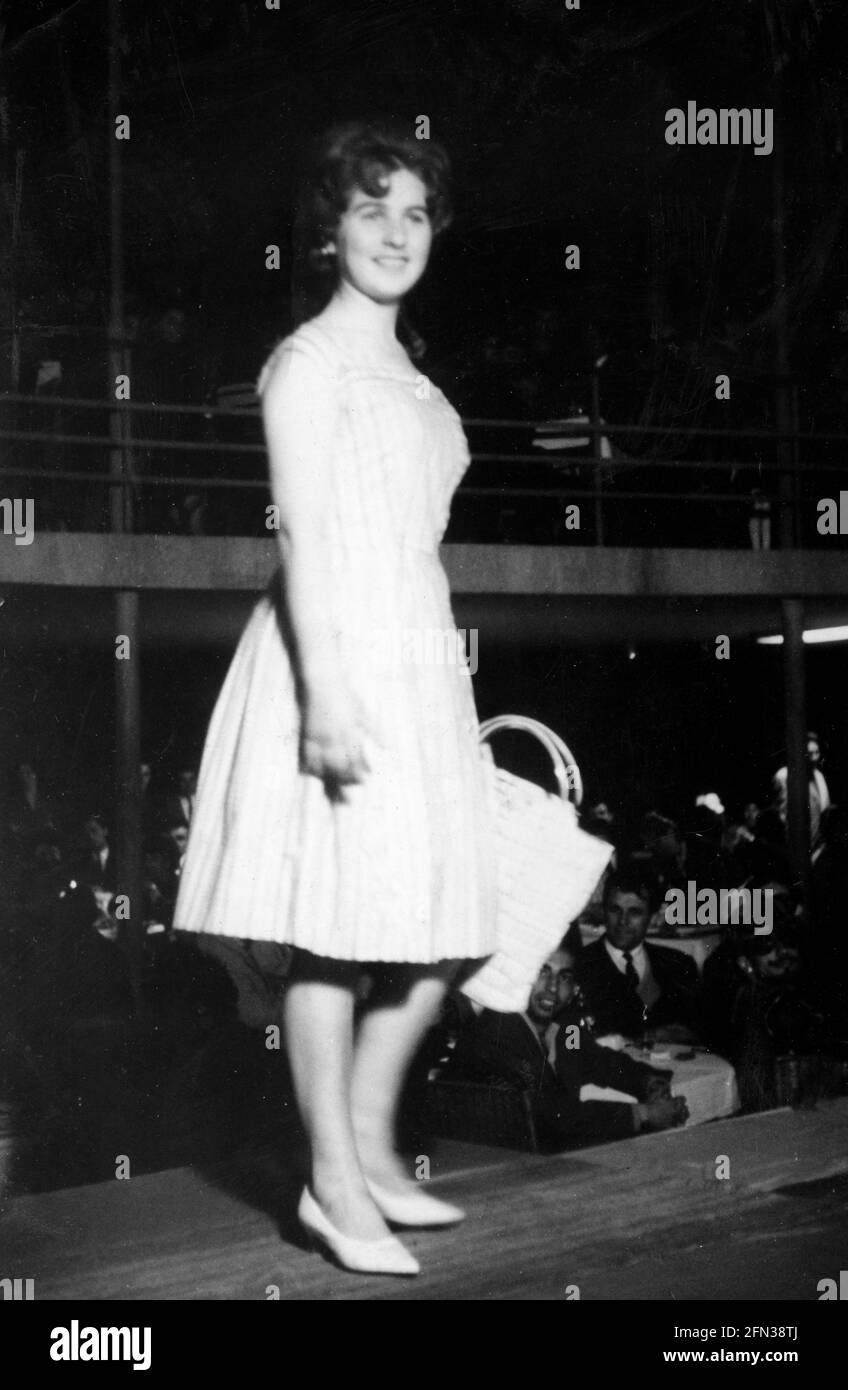 Young woman catwalking on platform ramp demonstrate clothing at an indoor fashion show in the 1960s, Bulgaria, Eastern Europe Stock Photo