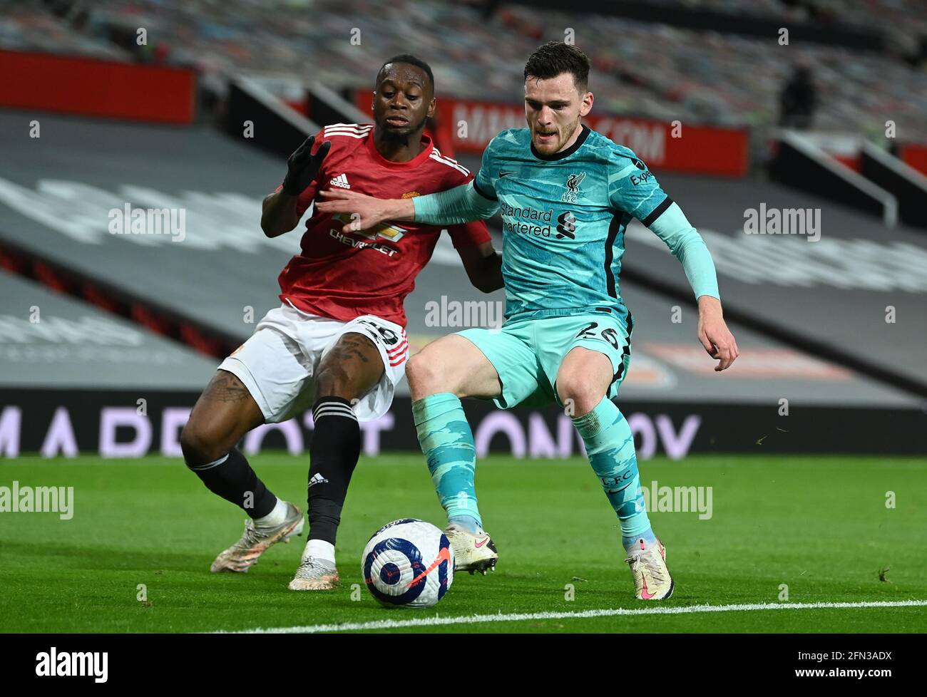 Manchester United's Aaron Wan-Bissaka (left) and Liverpool's Andrew Robertson battle for the ball during the Premier League match at Old Trafford, Manchester. Picture date: Thursday May 13, 2021. Stock Photo