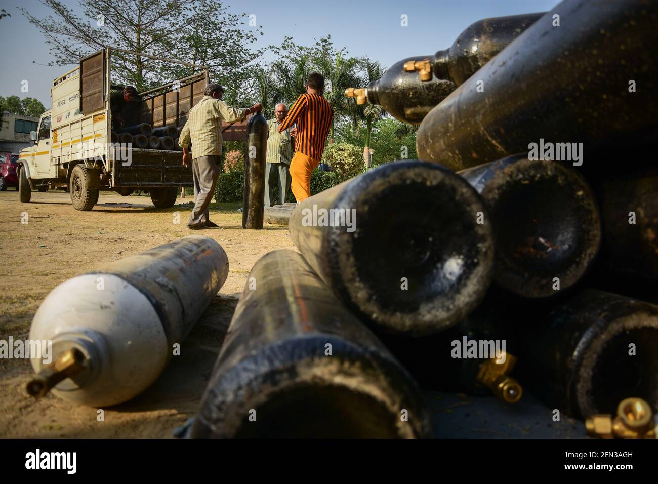 Workers loading and unloading medical oxygen cylinders at a care centre ...