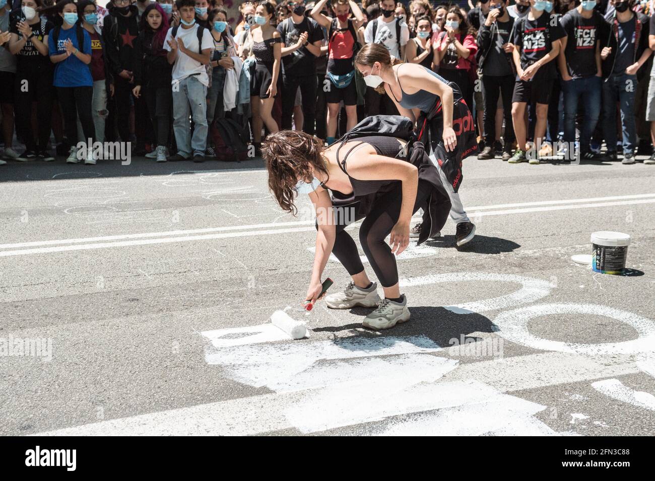 Protesters seen painting the road during the demonstration.Some 700 students have demonstrated in the center of Barcelona following the strike called by student unions. The strike is part of the campaign for the rectors to sign the 'Commitment against the educational crisis', where they ask for the equalization of prices of masters and degrees and the mandatory remuneration of internships. (Photo by Thiago Prudencio / SOPA Images/Sipa USA) Stock Photo