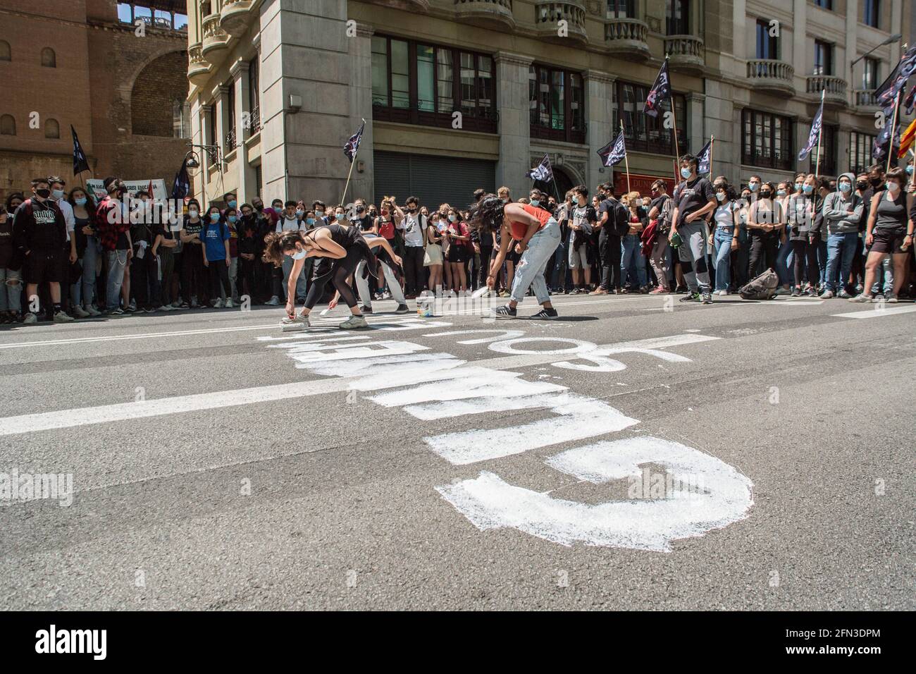 Barcelona, Spain. 13th May, 2021. Protesters seen painting the road during the demonstration.Around 700 students have demonstrated in the center of Barcelona following the strike called by student unions. The strike is part of the campaign for the rectors to sign the 'Commitment against the educational crisis', where they ask for the equalization of prices of masters and degrees and the mandatory remuneration of internships. Credit: SOPA Images Limited/Alamy Live News Stock Photo