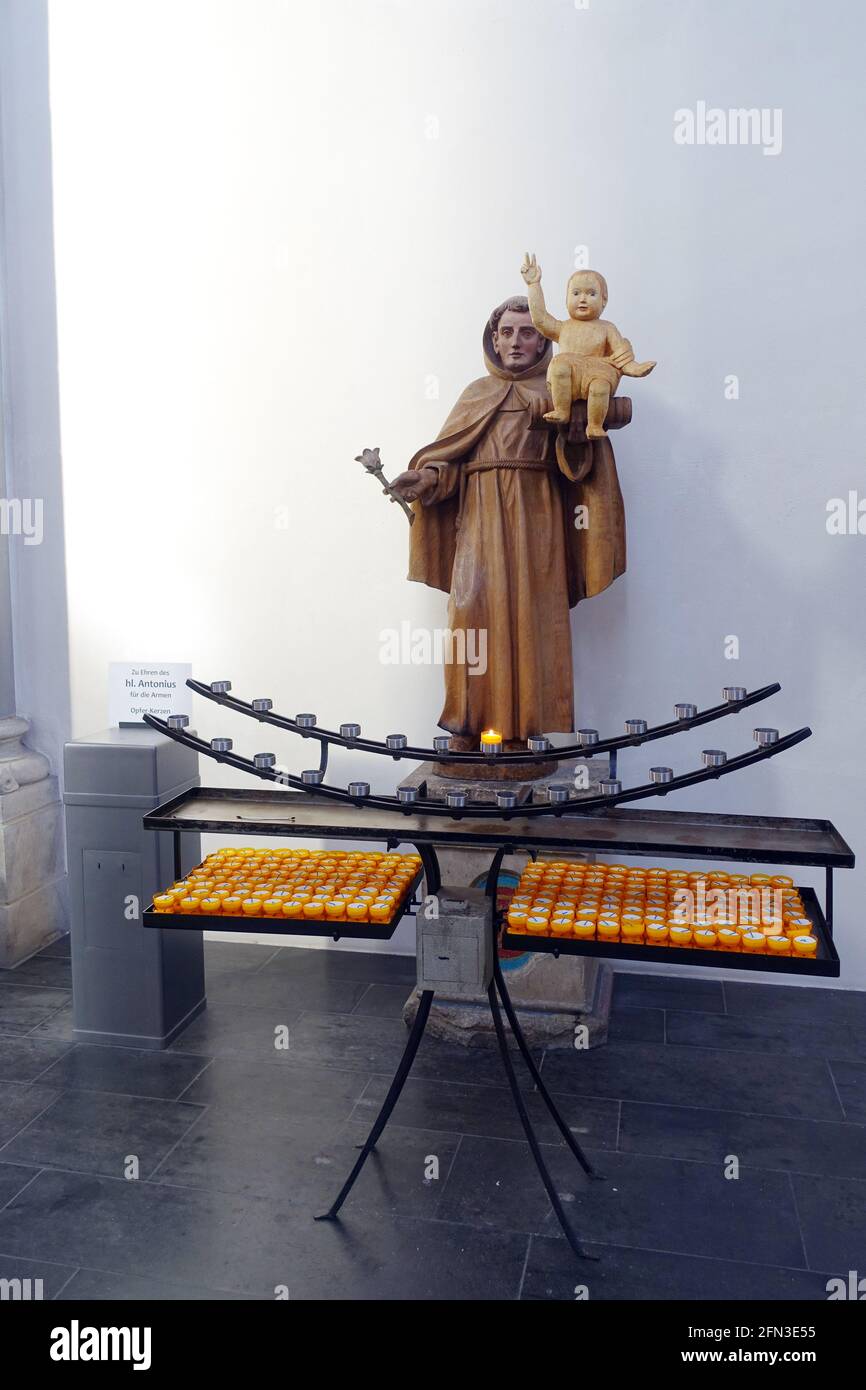 Innenansicht der romanischen Basilika St. Kunibert, Opferkerzen vor der Statue des Hl. Antonius, Köln, Nordrhein-Westfalen, Deutschland Stock Photo