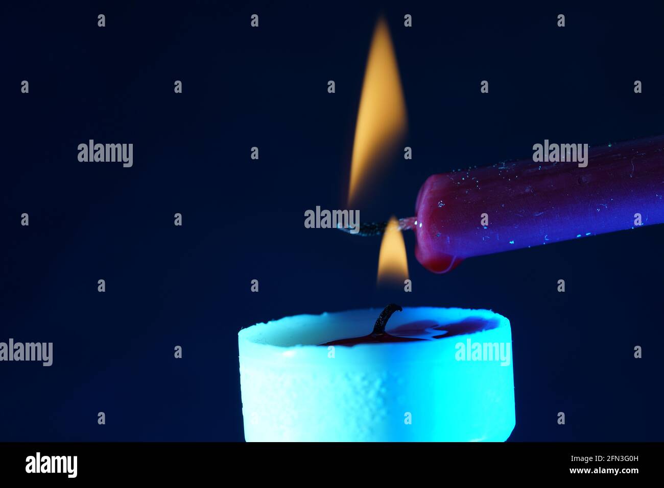 Shot of candle lighting another candle Stock Photo Alamy