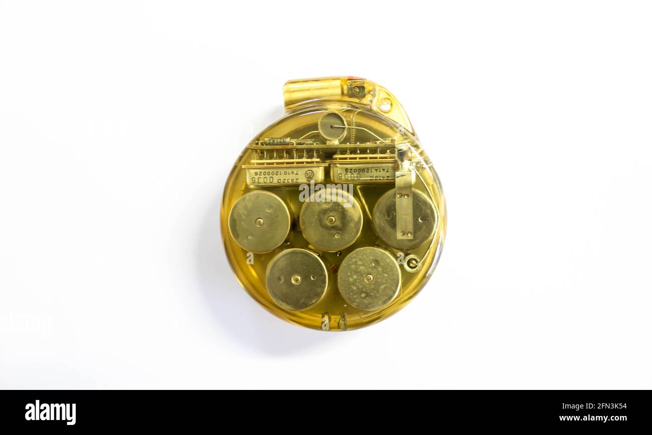 Cardiac pacemaker. Vintage implantable pacer, circular, transparent plastic encasing inner mechanics visible. Cardiology instrumentation, circa 1975. Stock Photo