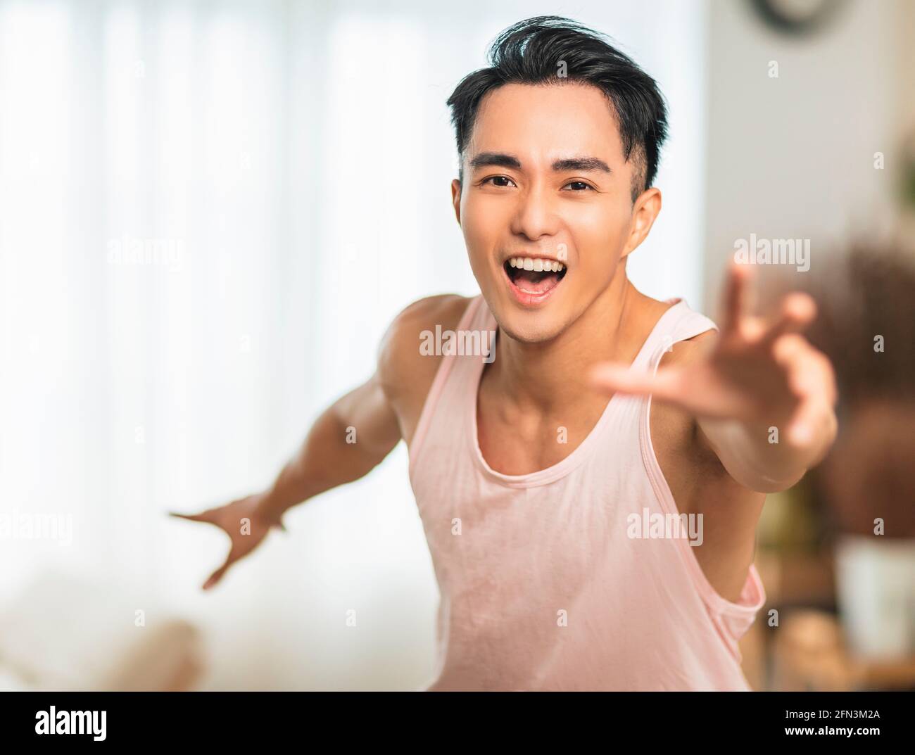 happy handsome young man looking at camera and exercise at home Stock Photo