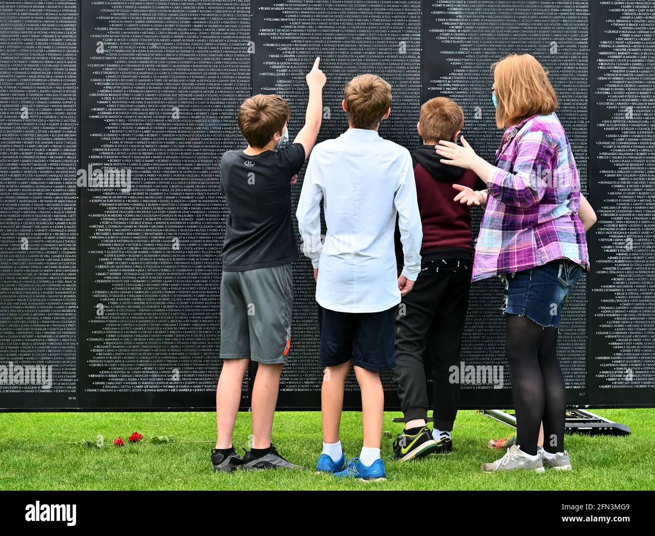 Tunkhannock, United States. 13th May, 2021. School children and a teacher look for a name on The Wall That Heals a replica of the National Vietnam Memorial.The Wall That Heals is a three-quarter scale replica of the Vietnam Veterans Memorial in Washington, DC, the wall travels around the country and is set up and displayed for 24 hours a day while it is in place. Credit: SOPA Images Limited/Alamy Live News Stock Photo