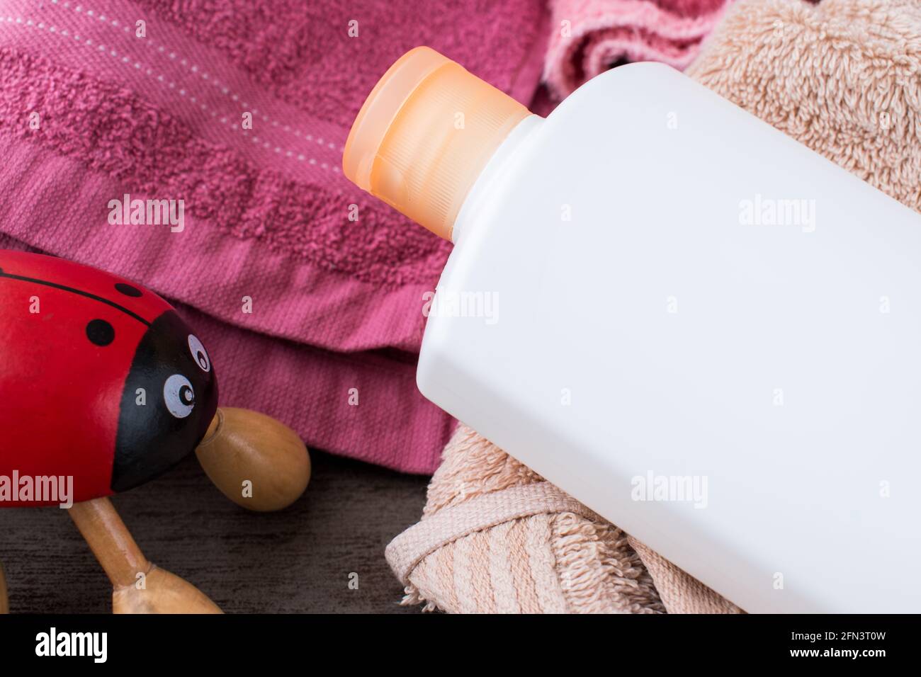 Red ladybug hand massager with some colorful towels on a wooden table in spa Stock Photo