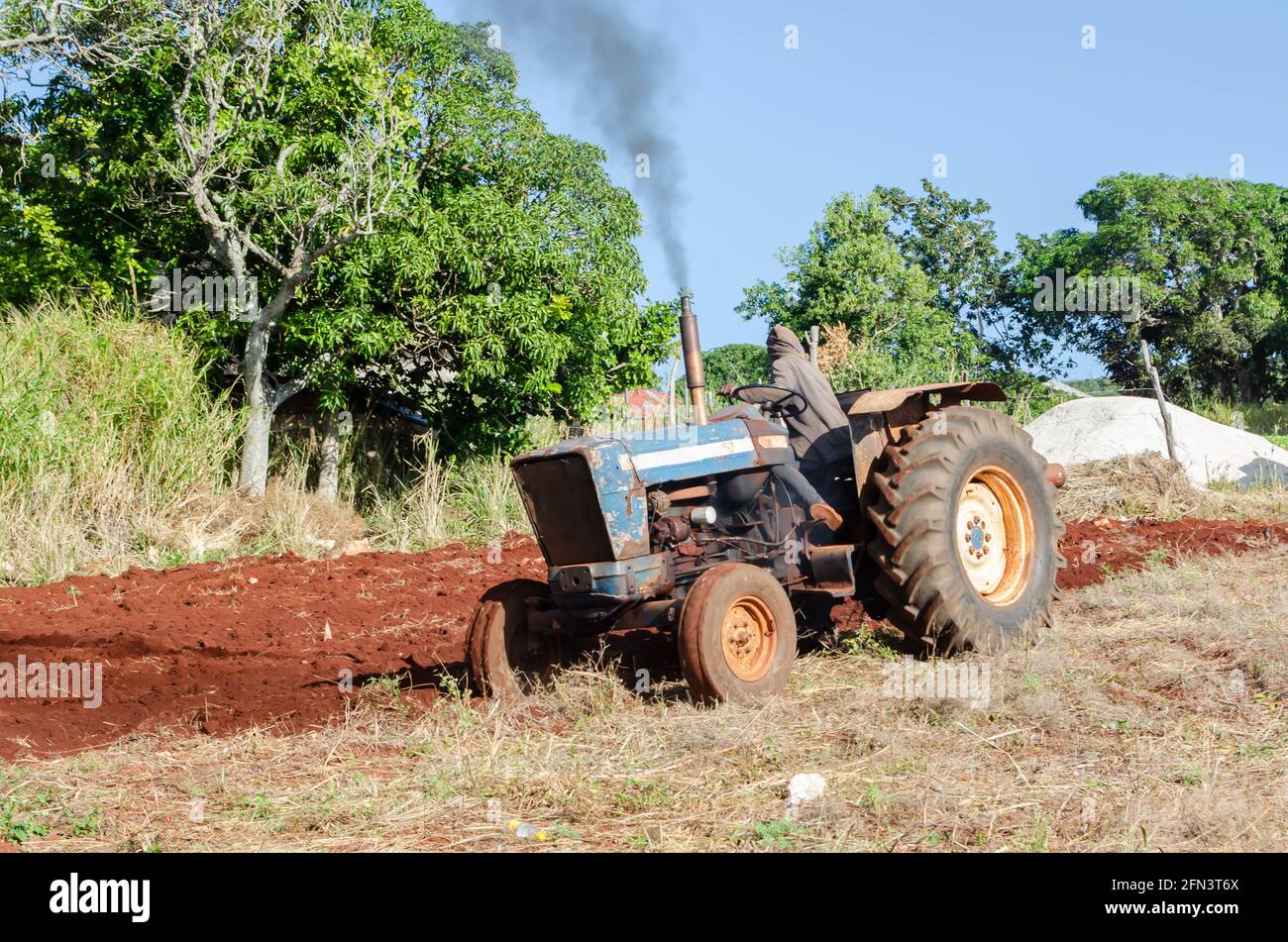 Tractor Plowing Land For Farming Stock Photo