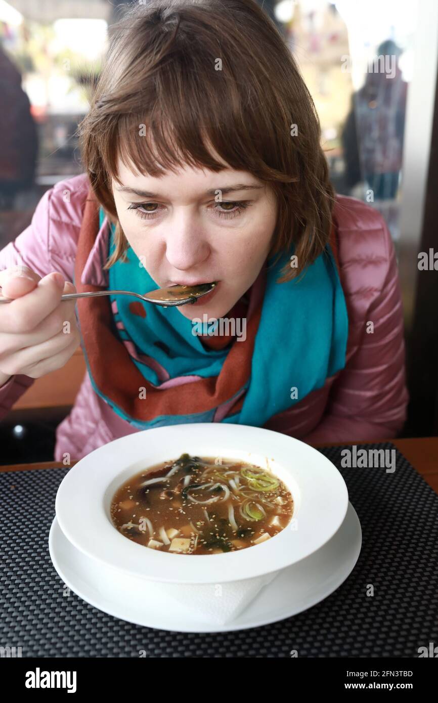 Woman eating Miso soup in a restaurant Stock Photo Alamy