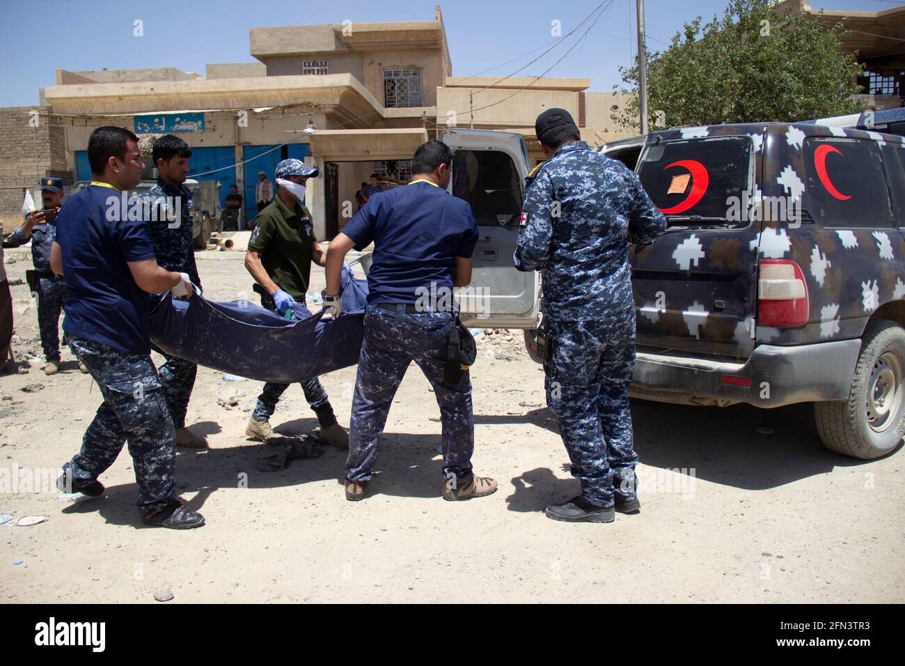 Iraqi Federal police load a body bag onto an ambulance during the 2016-2017 Mosul Operation. Stock Photo