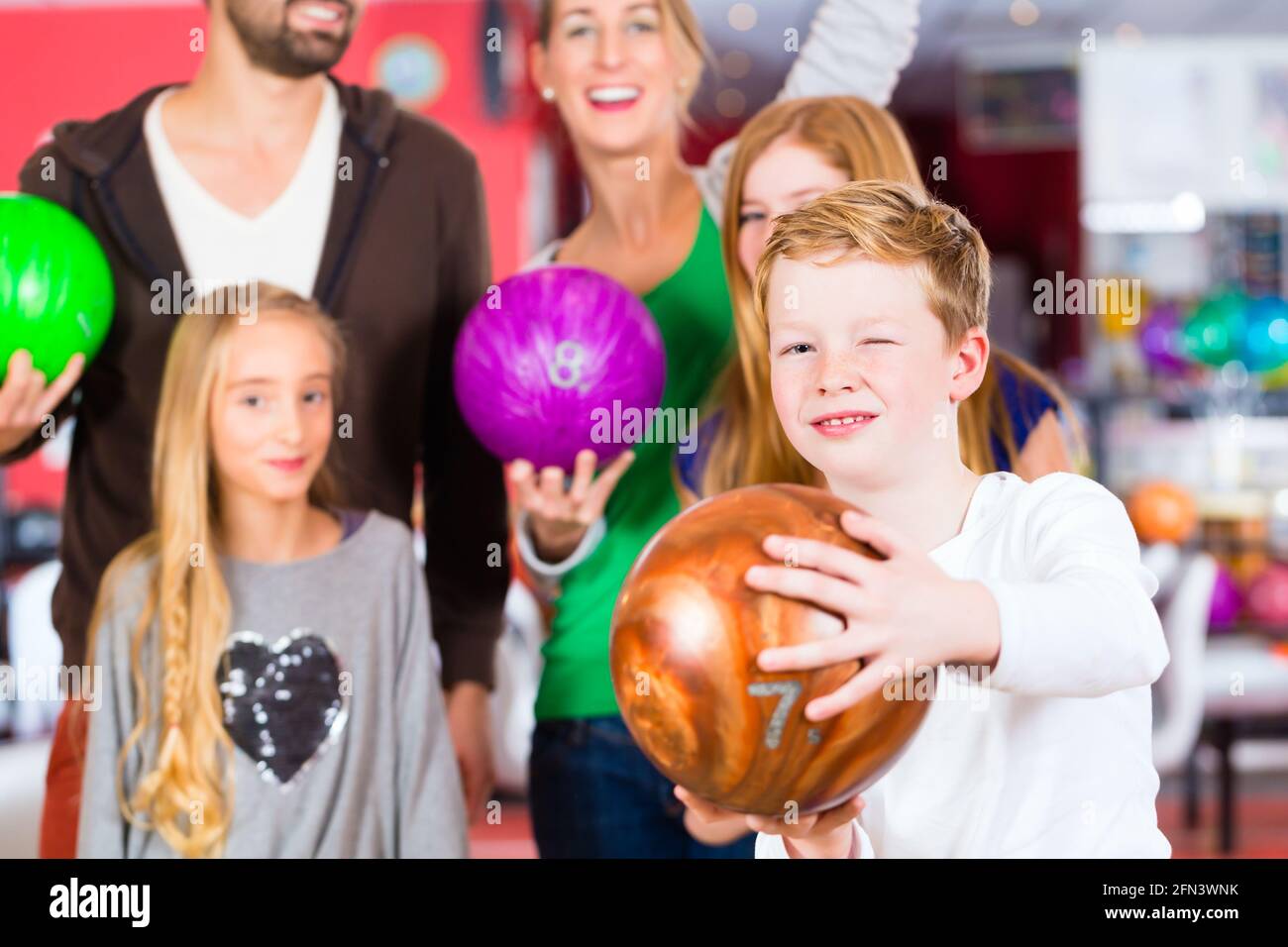 Parents playing with children together at bowling center Stock Photo Alamy