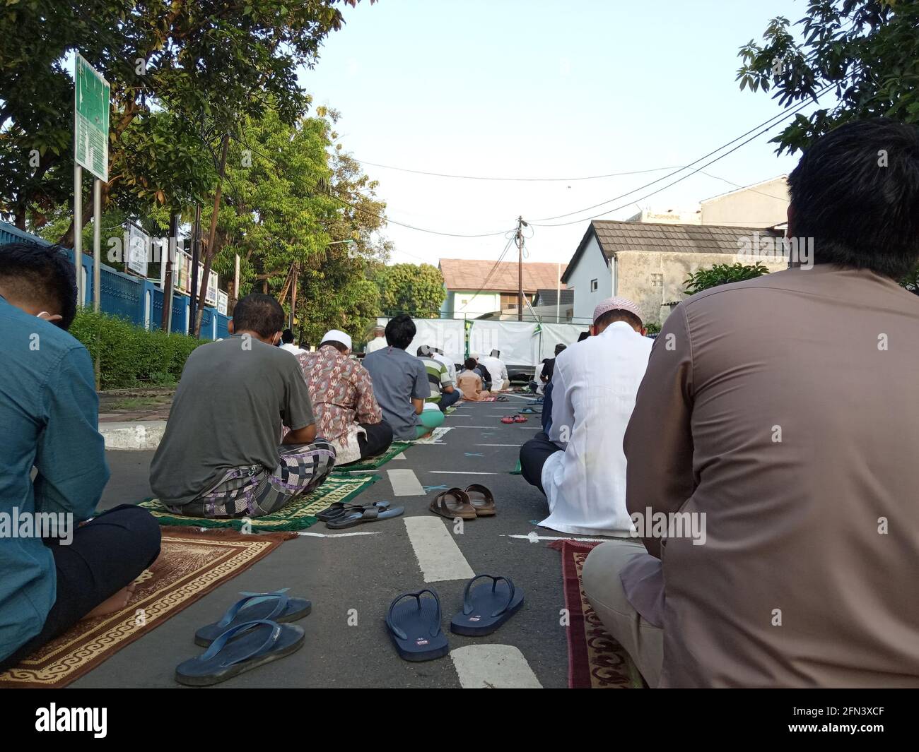 Editorial Photo, 13 May 2021, Indonesia, East Jakarta, at Street in Front of Mesjid or Fahahilah Mosque Sitting Islam Man using medincal Mask, Listeni Stock Photo