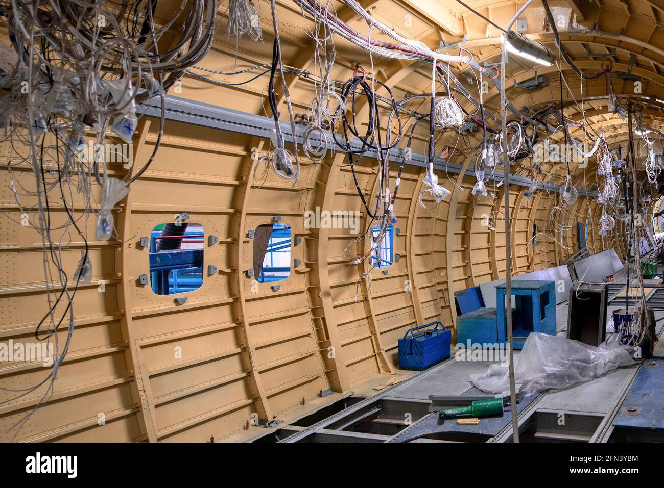 Construction of a new aircraft. Many electrical cables and wires hang from the sides of the