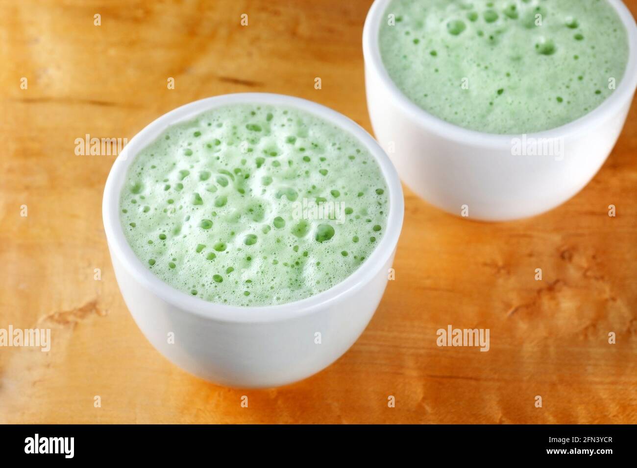 Two cups of matcha latte made with almond milk Stock Photo