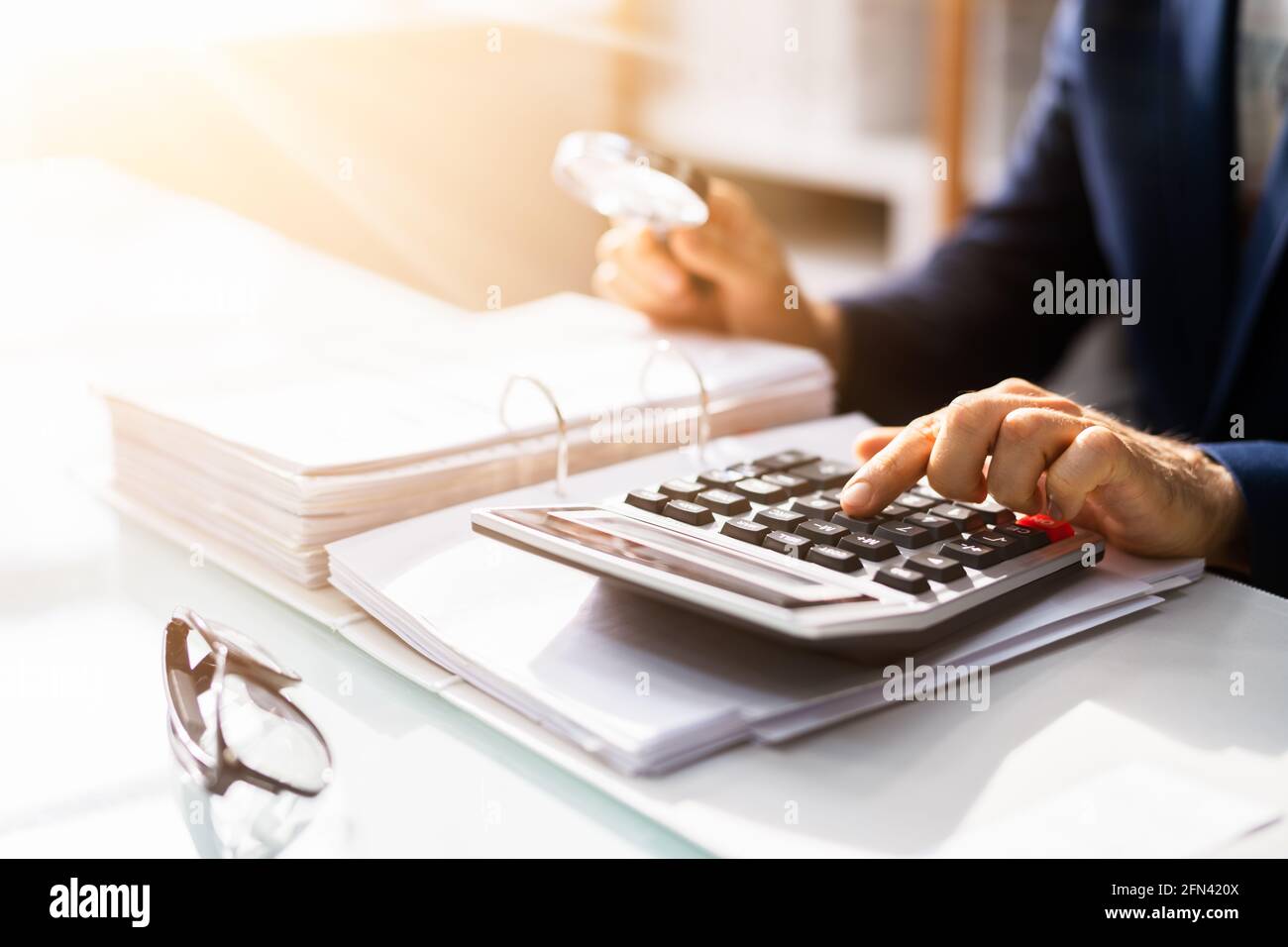 Corporate Auditor Using Magnifying Glass For Tax Fraud Audit Stock Photo