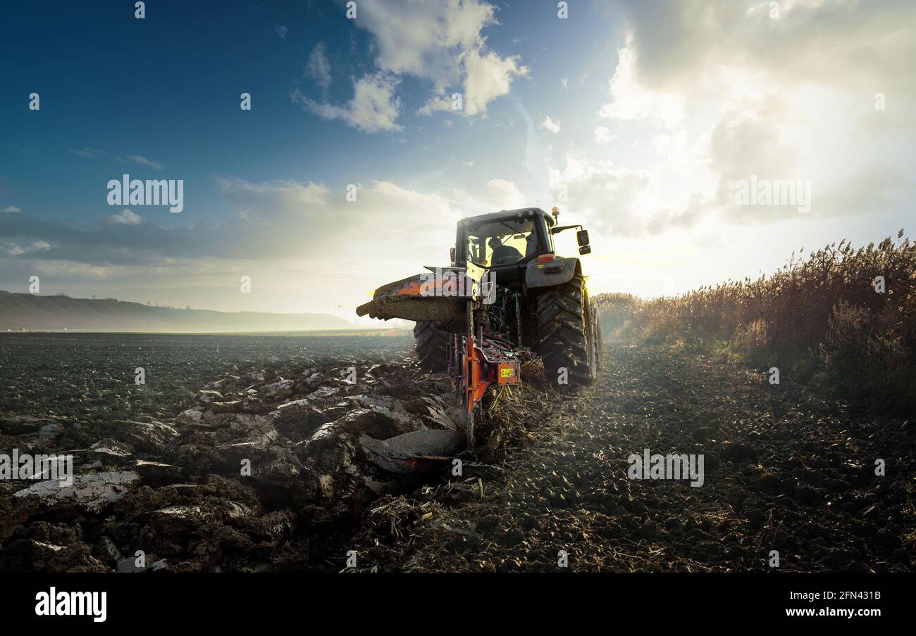 Tractor plowing field in rays hi-res stock photography and images - Alamy