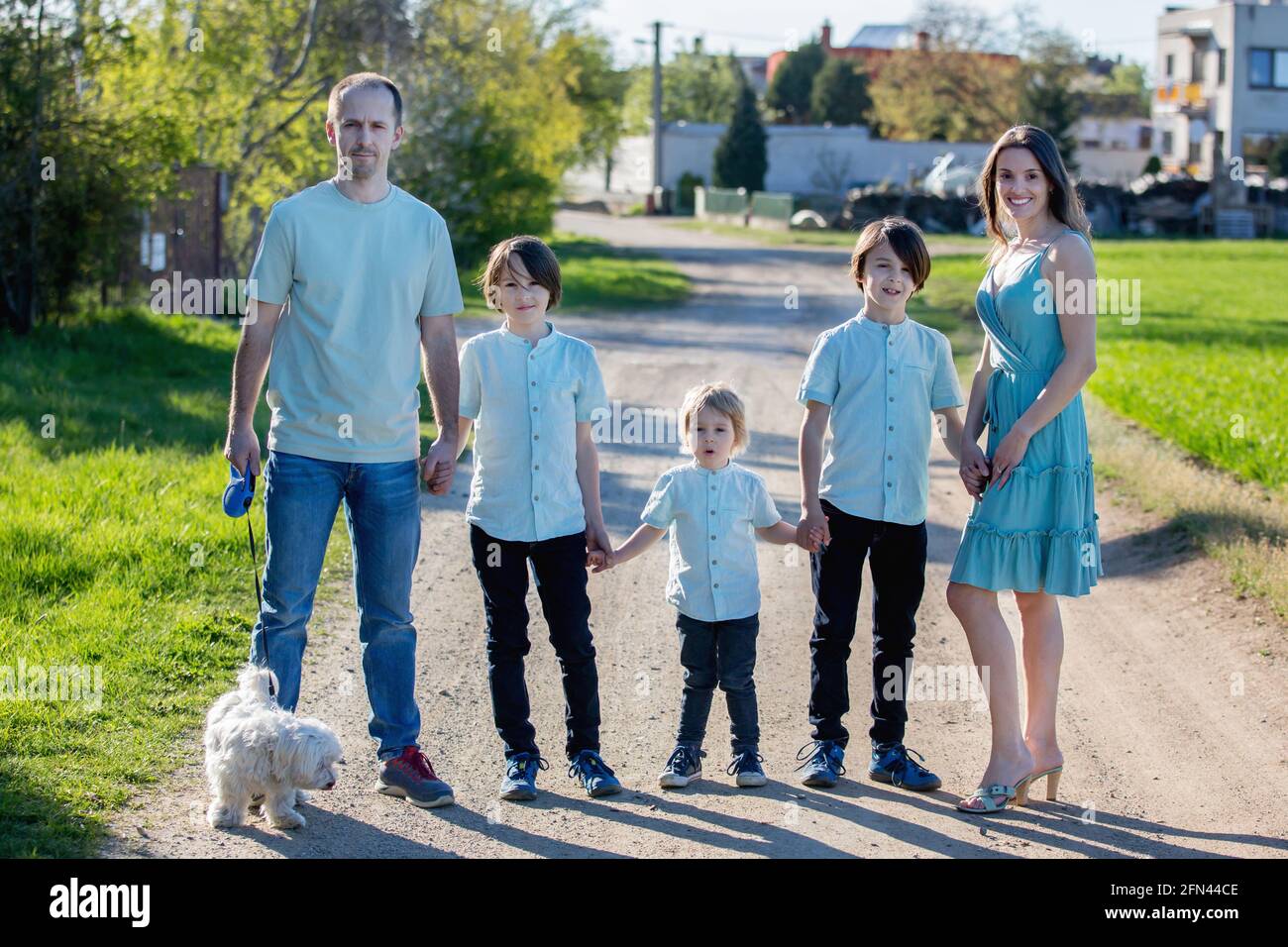 Beautiful family with kids, mom, dad, three boys and a dog, playing in ...