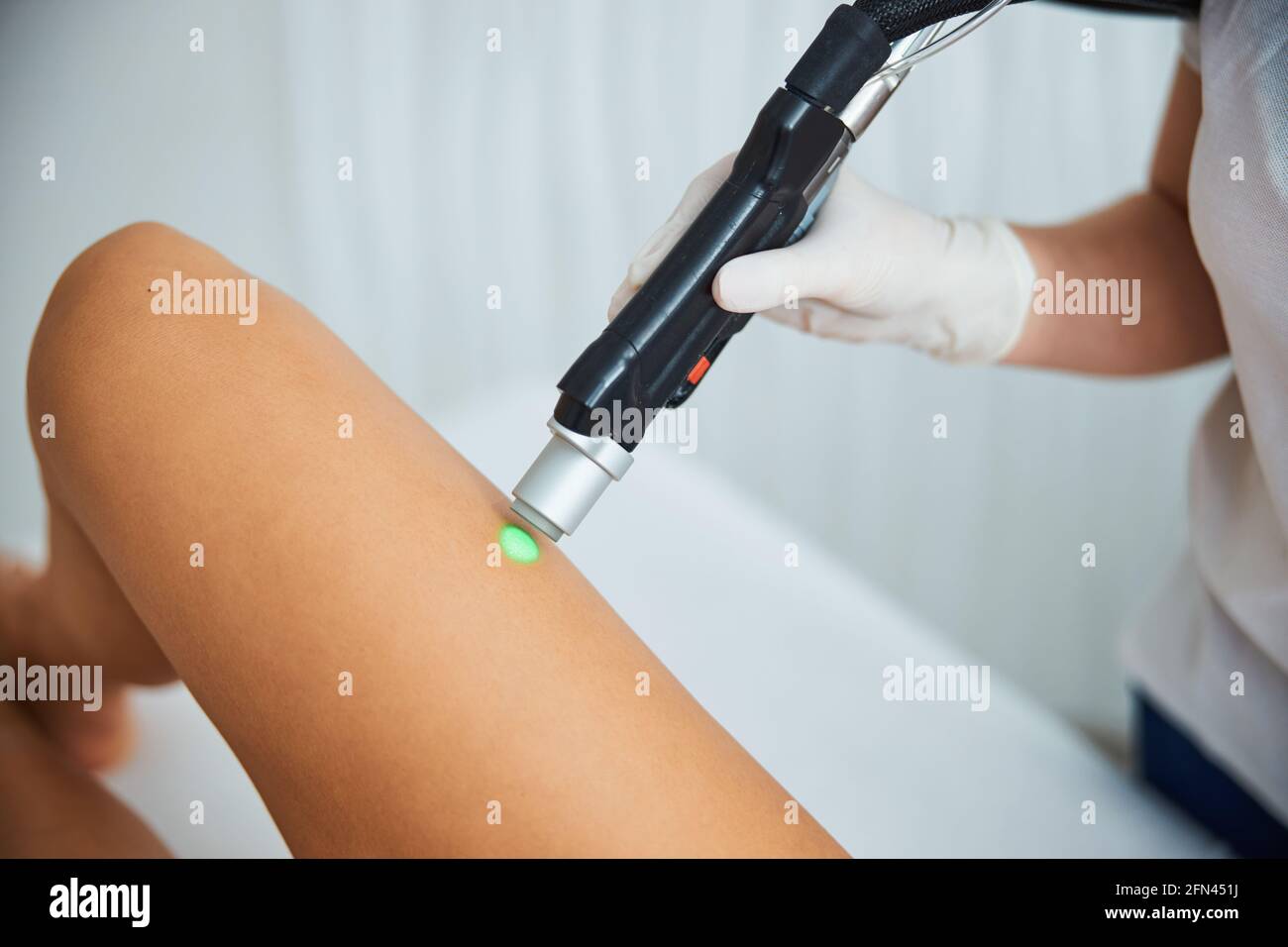 Spa client undergoing a professional leg hair removal procedure Stock Photo