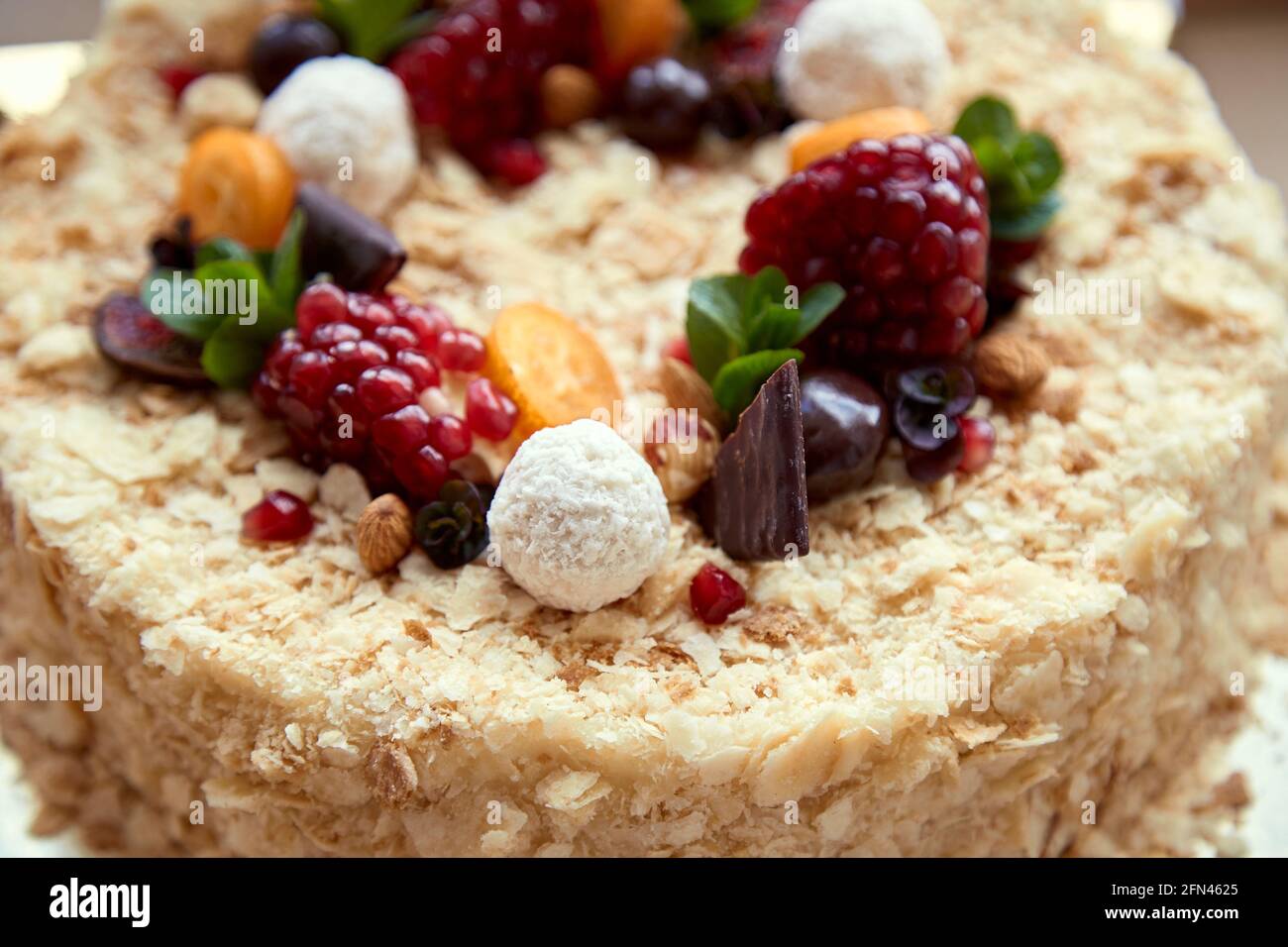 Birthday cake decorated with fruit, pomegranate seeds, chocolate and grapes. Top view. High quality photo Stock Photo