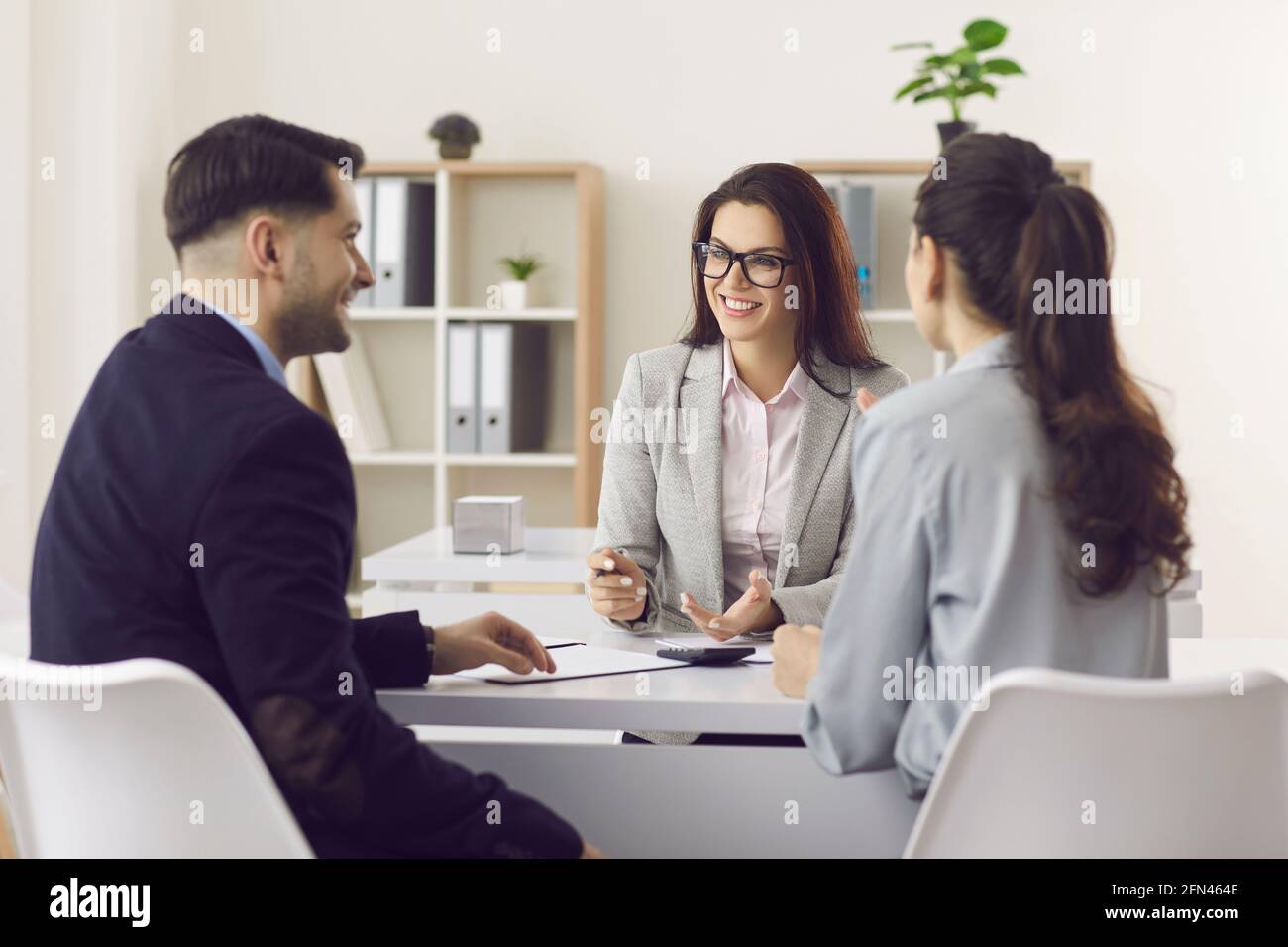 Woman financial advisor giving consultation to family couple about buying house Stock Photo