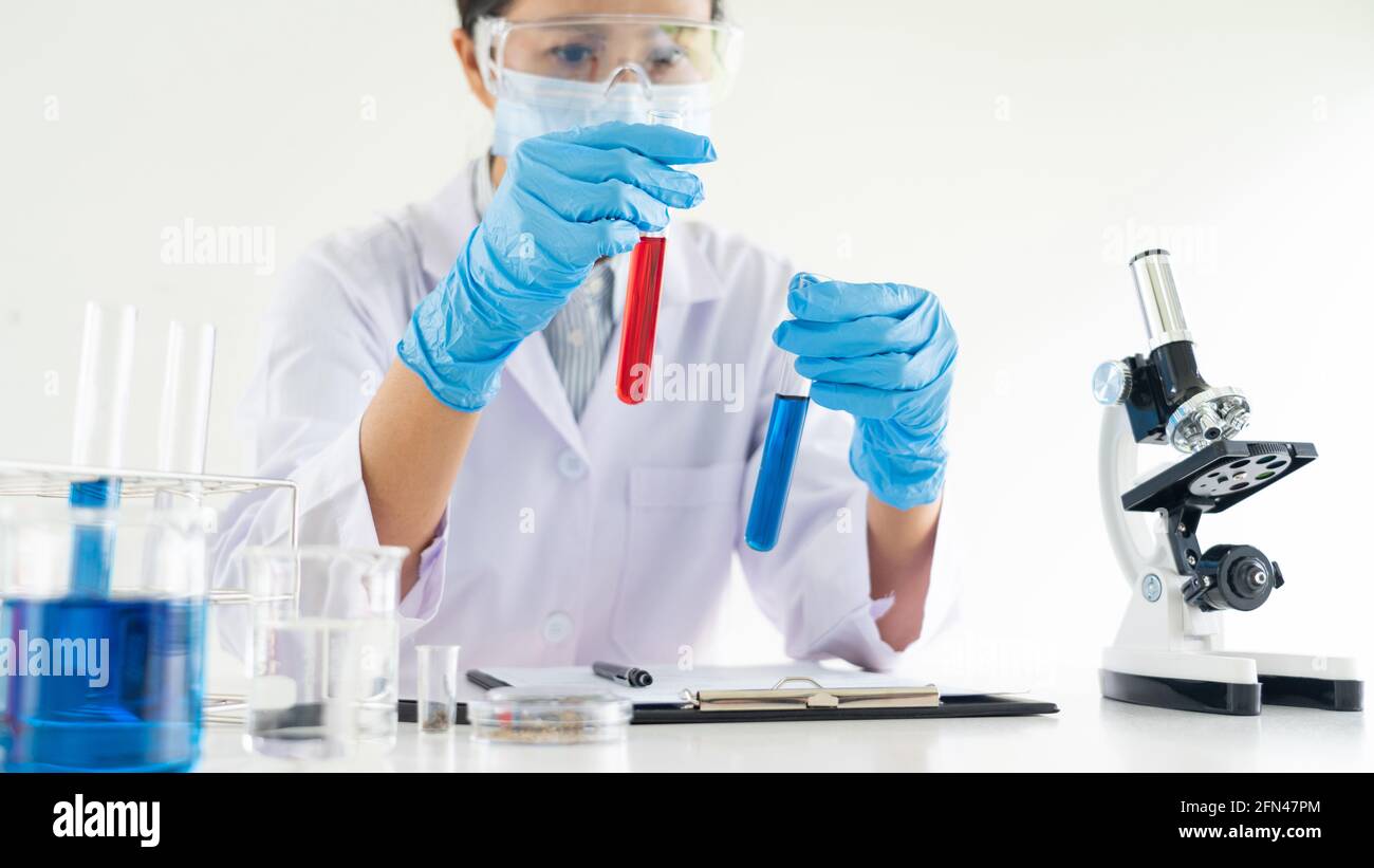 scientists researching in laboratory in white lab coat, gloves ...