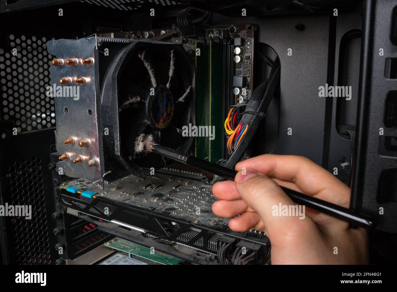 Computer Technology Engineer removes dust from PC hardware Stock Photo