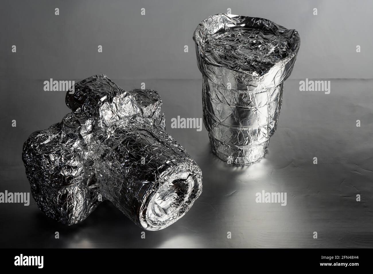 a camera and a lens wrapped in aluminum foil Stock Photo
