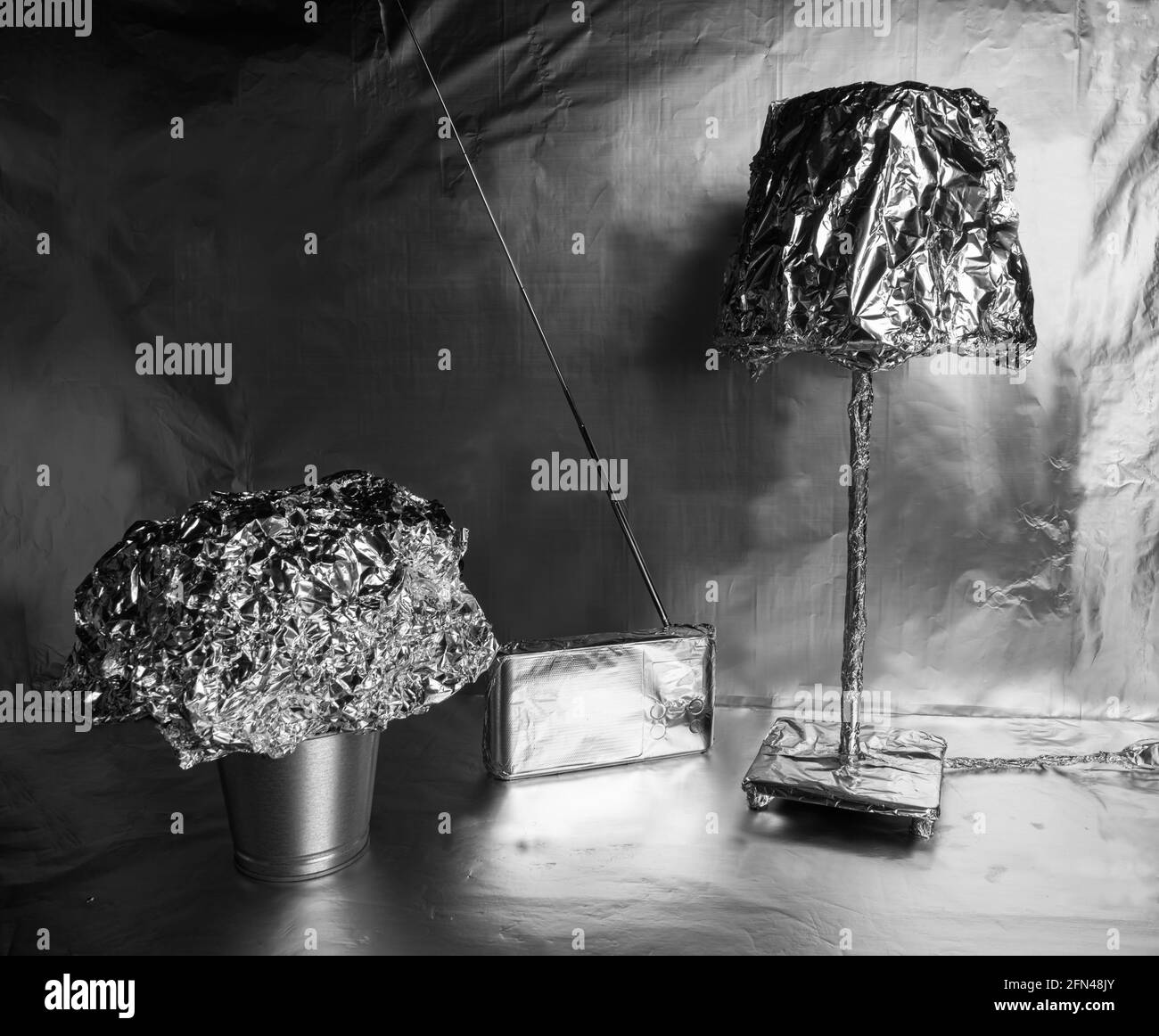 A lamp, a radio and a plant pot wrapped in aluminum foil Stock Photo