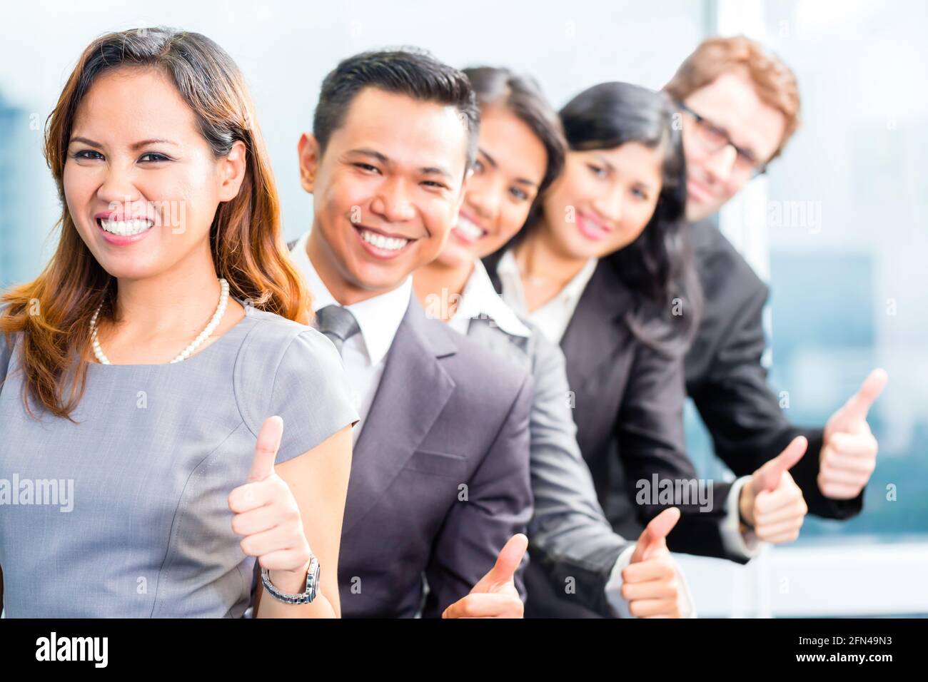 Portrait of Asian business team showing thumbs up Stock Photo - Alamy