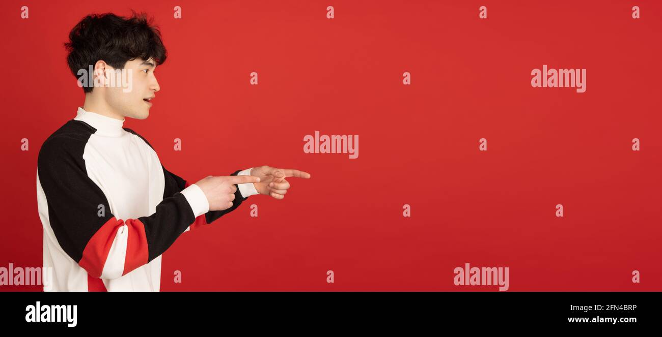 Asian man's portrait isolated over red studio background with copyspace ...