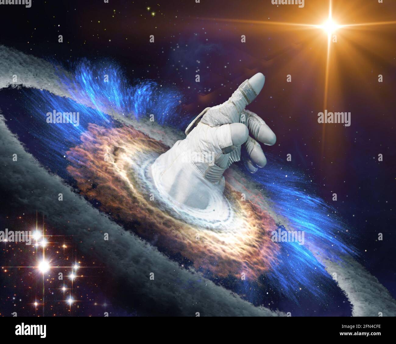 Astronaut hand in gloves points with finger to a shining star in space through a black hole portal. Exploration concept. Elements of this image furnis Stock Photo
