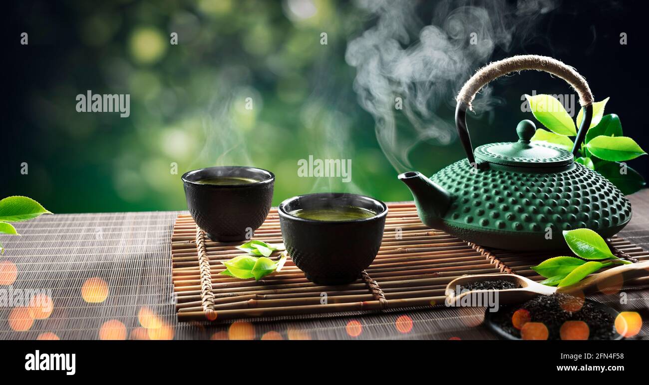 Japanese Tea - Hot Teapot And Teacups On Bamboo Mat Stock Photo